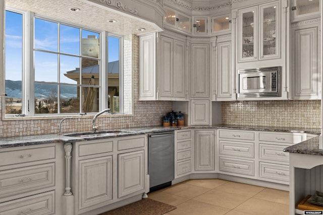 kitchen with light tile patterned flooring, appliances with stainless steel finishes, sink, and a wealth of natural light