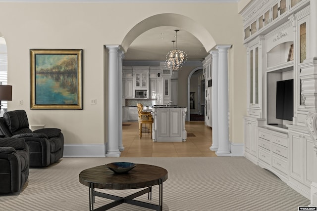 living room with ornate columns, ornamental molding, light tile patterned floors, and a chandelier