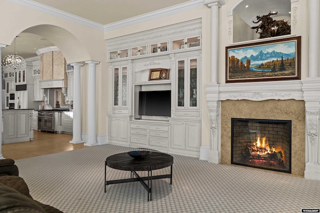 living room featuring light carpet, crown molding, decorative columns, and a premium fireplace