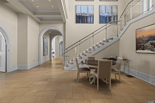 foyer featuring coffered ceiling, crown molding, light tile patterned floors, beam ceiling, and a high ceiling