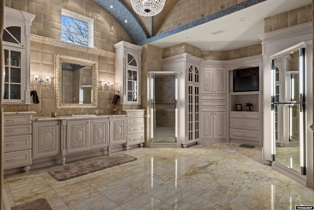 bathroom with vanity and high vaulted ceiling