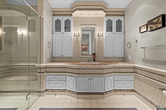 bathroom featuring walk in shower, sink, and tile walls