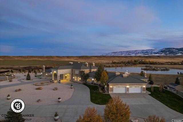 view of front facade featuring a garage and a water and mountain view