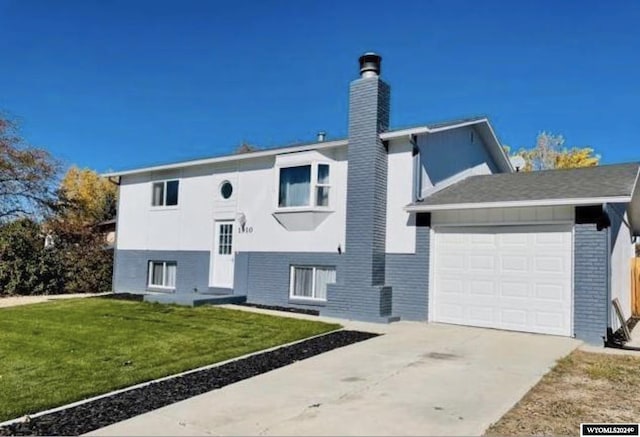 view of front of home with a garage, concrete driveway, a chimney, a front lawn, and brick siding