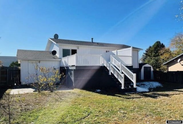 rear view of house featuring a deck, an outbuilding, stairway, a lawn, and a storage unit