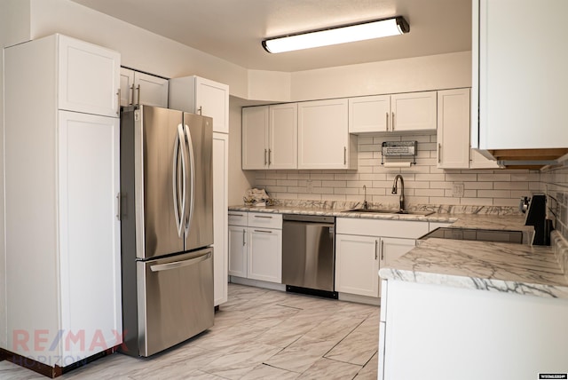 kitchen featuring stainless steel appliances, light countertops, a sink, and white cabinetry