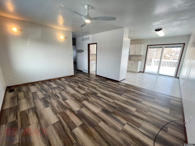 interior space with visible vents, ceiling fan, baseboards, and wood finished floors