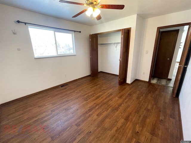 unfurnished bedroom featuring a closet, dark wood-style flooring, visible vents, and a ceiling fan