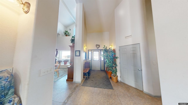 tiled foyer entrance featuring high vaulted ceiling