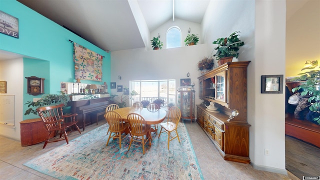 dining area with high vaulted ceiling