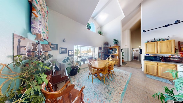 dining room with high vaulted ceiling and light tile patterned floors