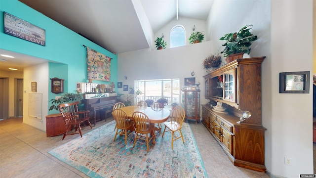 dining room featuring high vaulted ceiling and light tile patterned floors