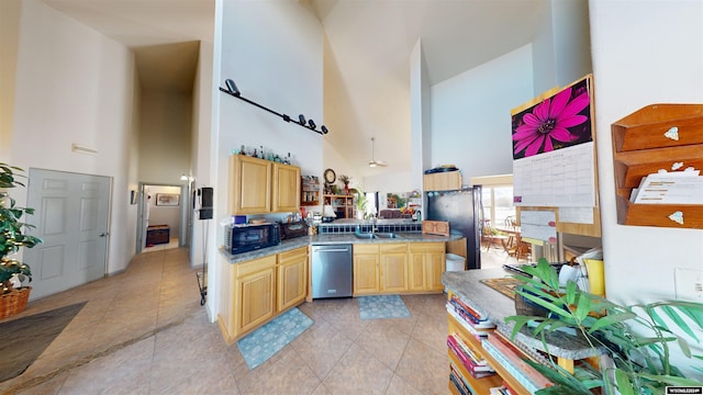 kitchen featuring dishwasher, a high ceiling, sink, light tile patterned floors, and light brown cabinetry