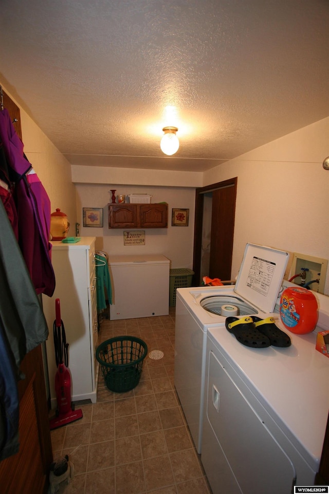 laundry area with hookup for a washing machine, tile flooring, washing machine and dryer, and a textured ceiling