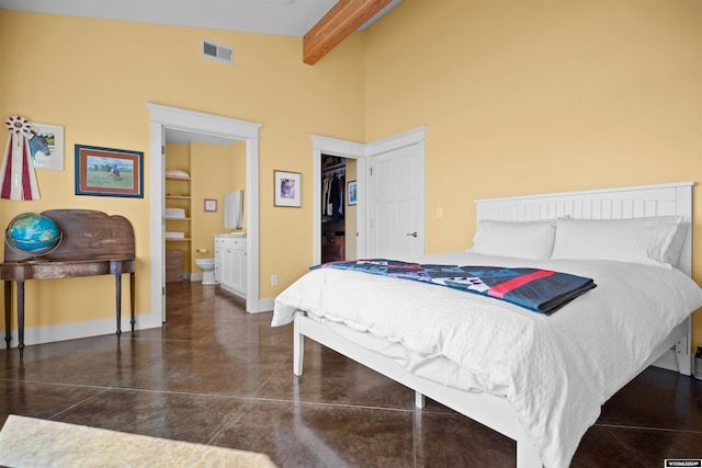 bedroom featuring a closet, a walk in closet, high vaulted ceiling, beam ceiling, and ensuite bathroom