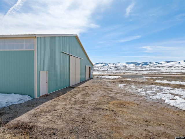 snow covered structure featuring a mountain view