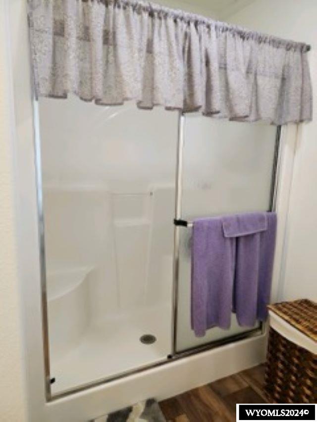 bathroom with wood-type flooring and walk in shower