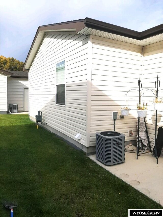 view of home's exterior featuring a lawn, a patio, and central AC