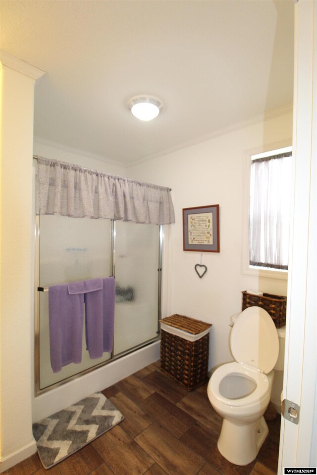 bathroom featuring toilet, an enclosed shower, wood-type flooring, and ornamental molding