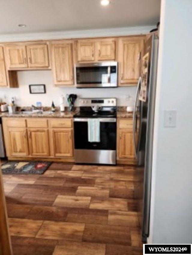 kitchen featuring appliances with stainless steel finishes, dark hardwood / wood-style flooring, and a barn door