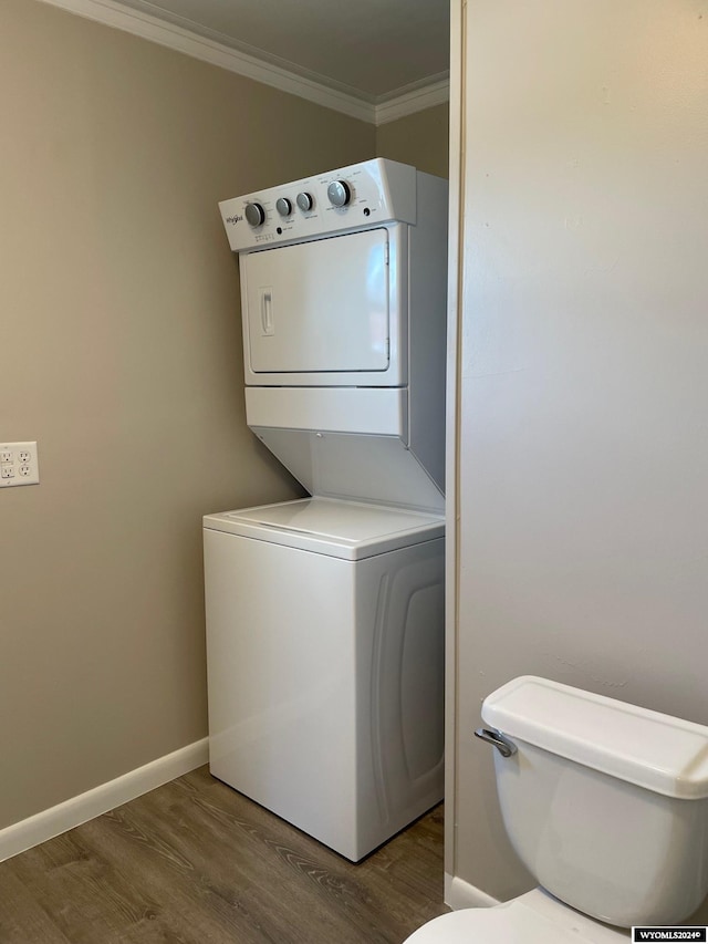 washroom featuring stacked washer and clothes dryer, dark hardwood / wood-style floors, and crown molding