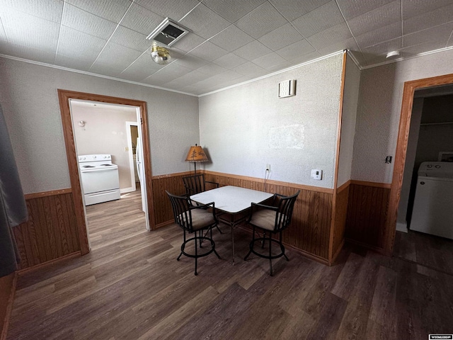 dining space featuring crown molding, dark hardwood / wood-style floors, and washer / clothes dryer