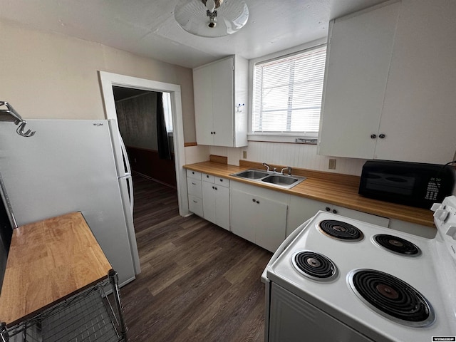 kitchen featuring dark hardwood / wood-style flooring, sink, white fridge, and white cabinets