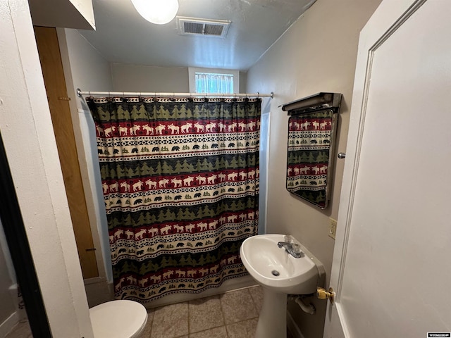 bathroom with tile flooring and toilet