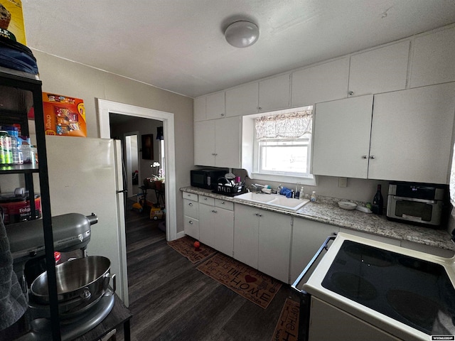 kitchen featuring dark hardwood / wood-style floors, sink, refrigerator, stove, and white cabinets