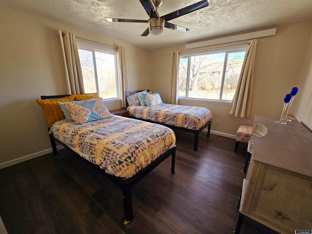 bedroom with a textured ceiling, multiple windows, dark hardwood / wood-style floors, and ceiling fan