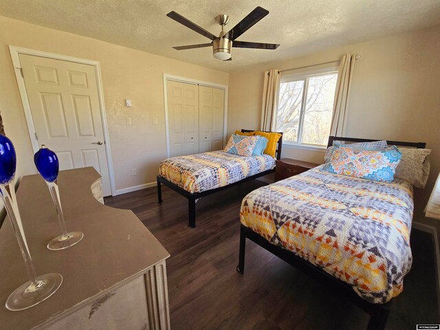 bedroom with ceiling fan, a textured ceiling, dark hardwood / wood-style floors, and a closet