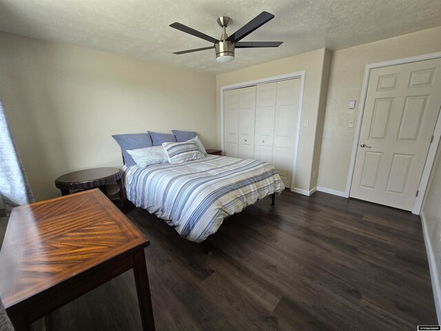 bedroom with ceiling fan, a closet, dark wood-type flooring, and a textured ceiling