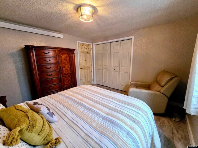 bedroom with dark hardwood / wood-style flooring, a closet, and a textured ceiling