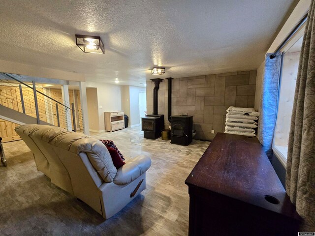 living room with a wood stove and a textured ceiling