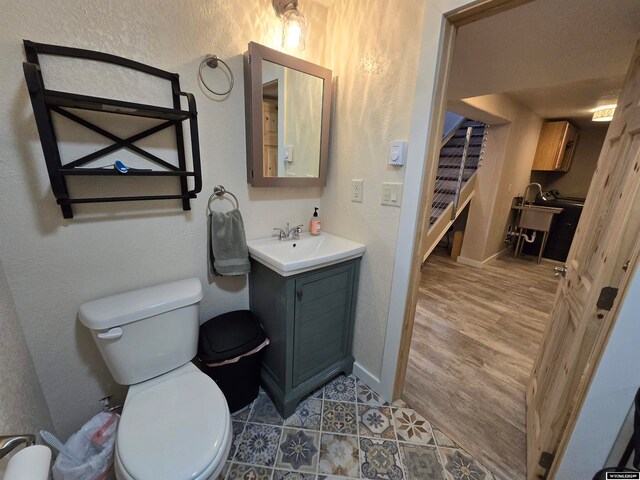 bathroom with tile flooring, toilet, and vanity