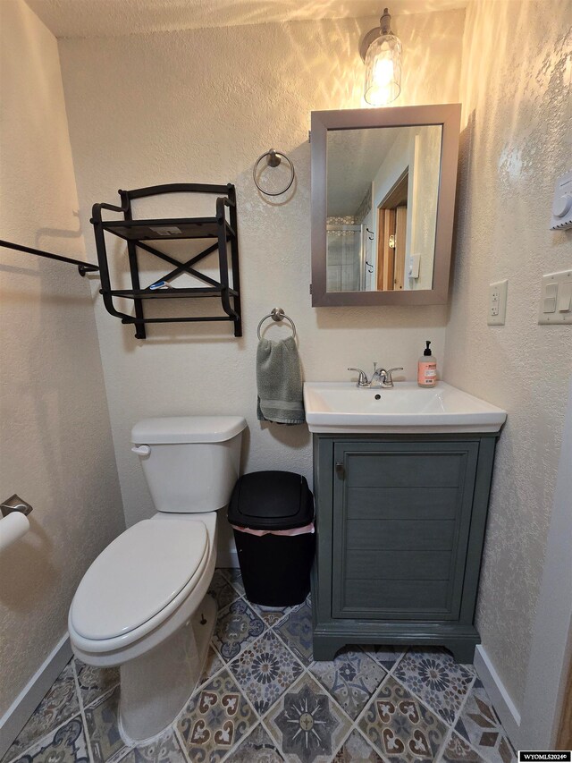 bathroom featuring toilet, tile floors, and vanity