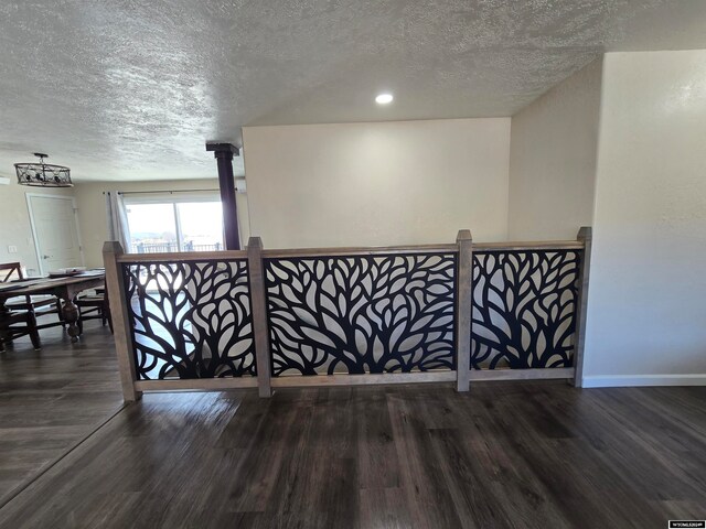 interior space featuring dark hardwood / wood-style flooring, a textured ceiling, and a wood stove