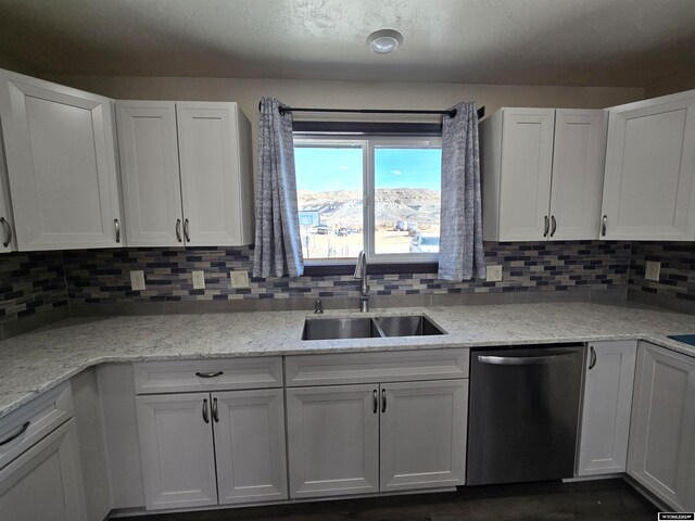 kitchen with white cabinets, tasteful backsplash, dishwasher, and sink