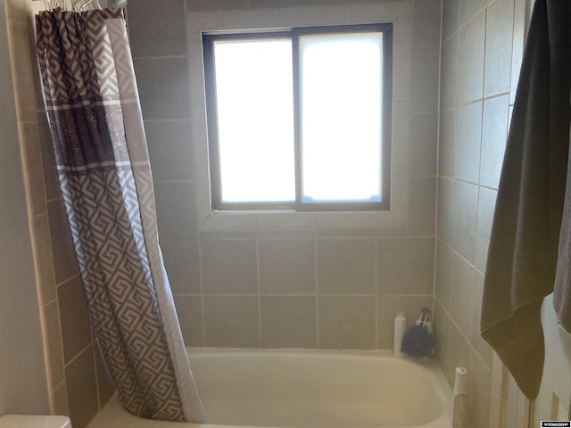 bathroom with a wealth of natural light and shower / bath combo