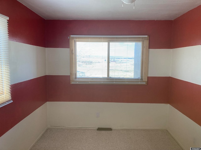 spare room featuring a healthy amount of sunlight and carpet flooring