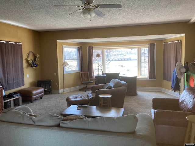 carpeted living room featuring ceiling fan and a textured ceiling