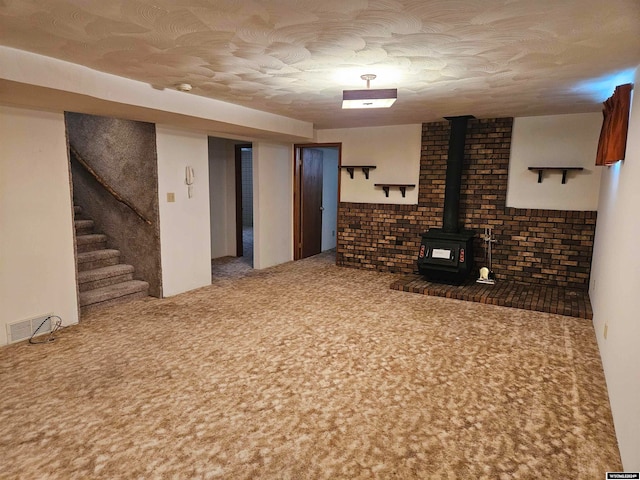 basement with brick wall, dark colored carpet, and a wood stove