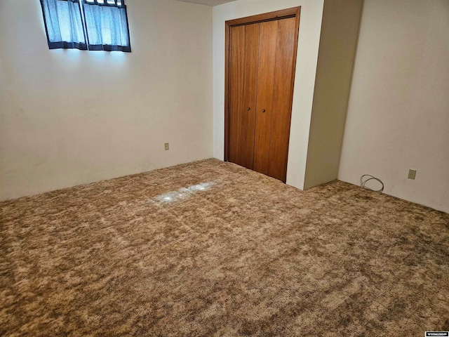 unfurnished bedroom with a closet and carpet floors