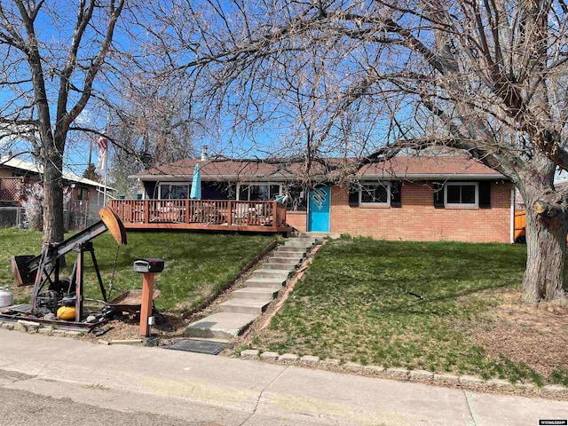 ranch-style home featuring a wooden deck and a front yard