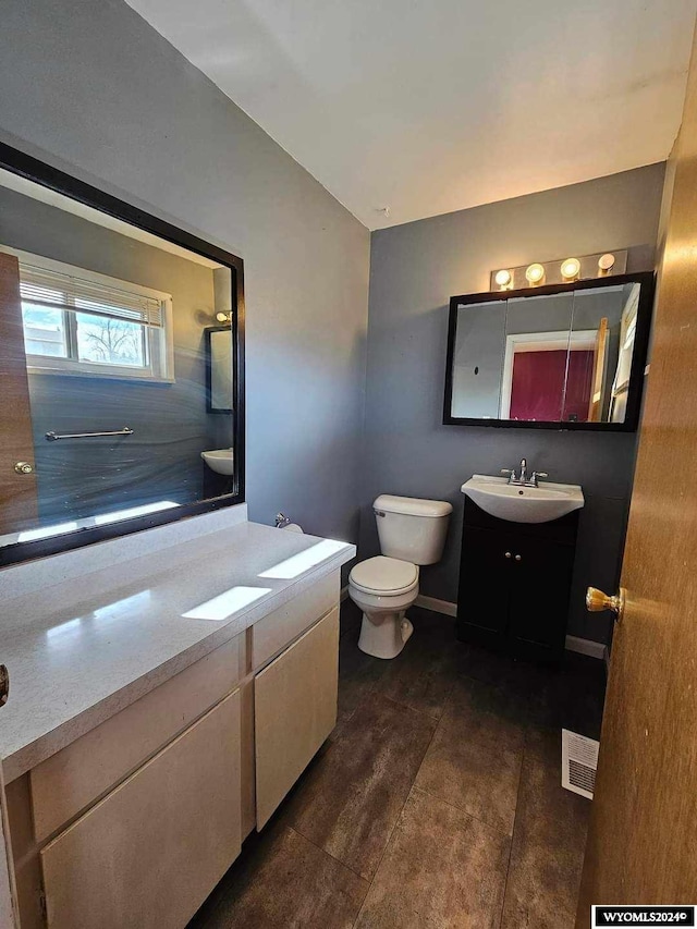 bathroom with tile floors, vanity, and toilet