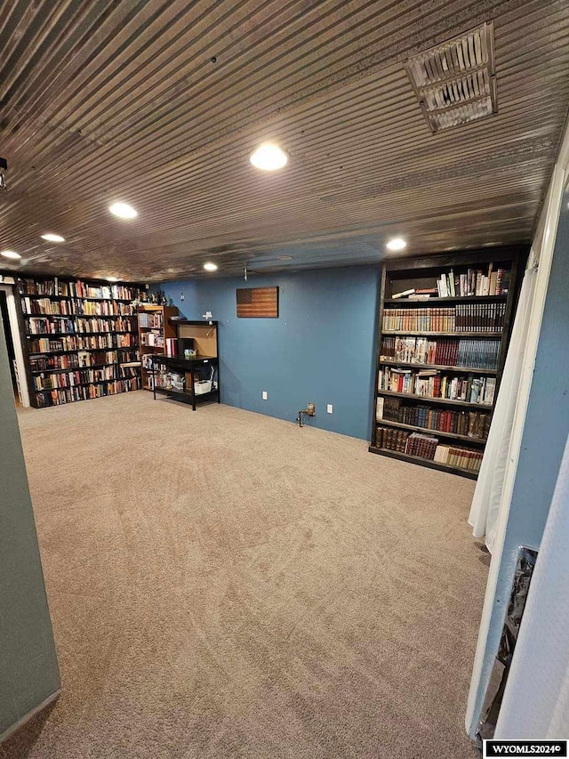 basement featuring built in features, carpet, and wood ceiling