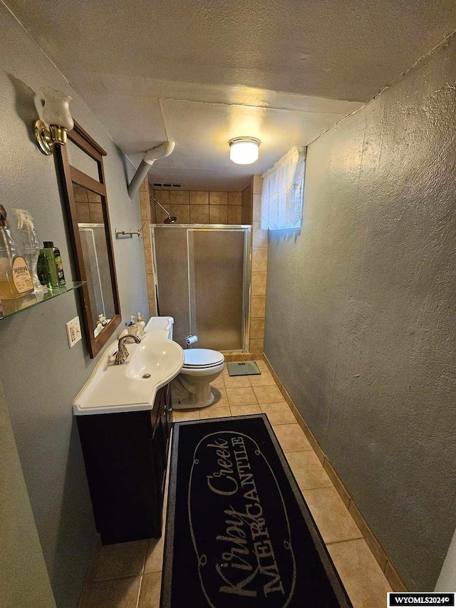 bathroom featuring walk in shower, vanity with extensive cabinet space, toilet, a textured ceiling, and tile floors