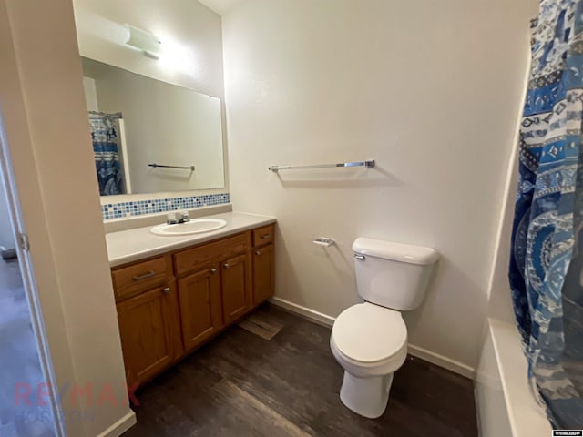 full bathroom with shower / tub combo, vanity, hardwood / wood-style flooring, and toilet