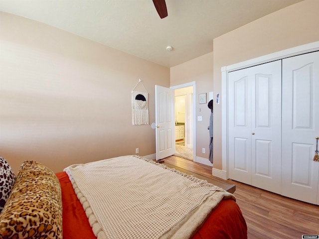 bedroom with ceiling fan, light hardwood / wood-style floors, and a closet