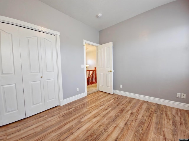 unfurnished bedroom featuring light hardwood / wood-style flooring and a closet